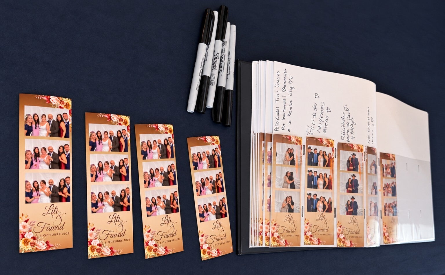 Open photo album guestbook with photo booth strips, handwritten messages, and pens.