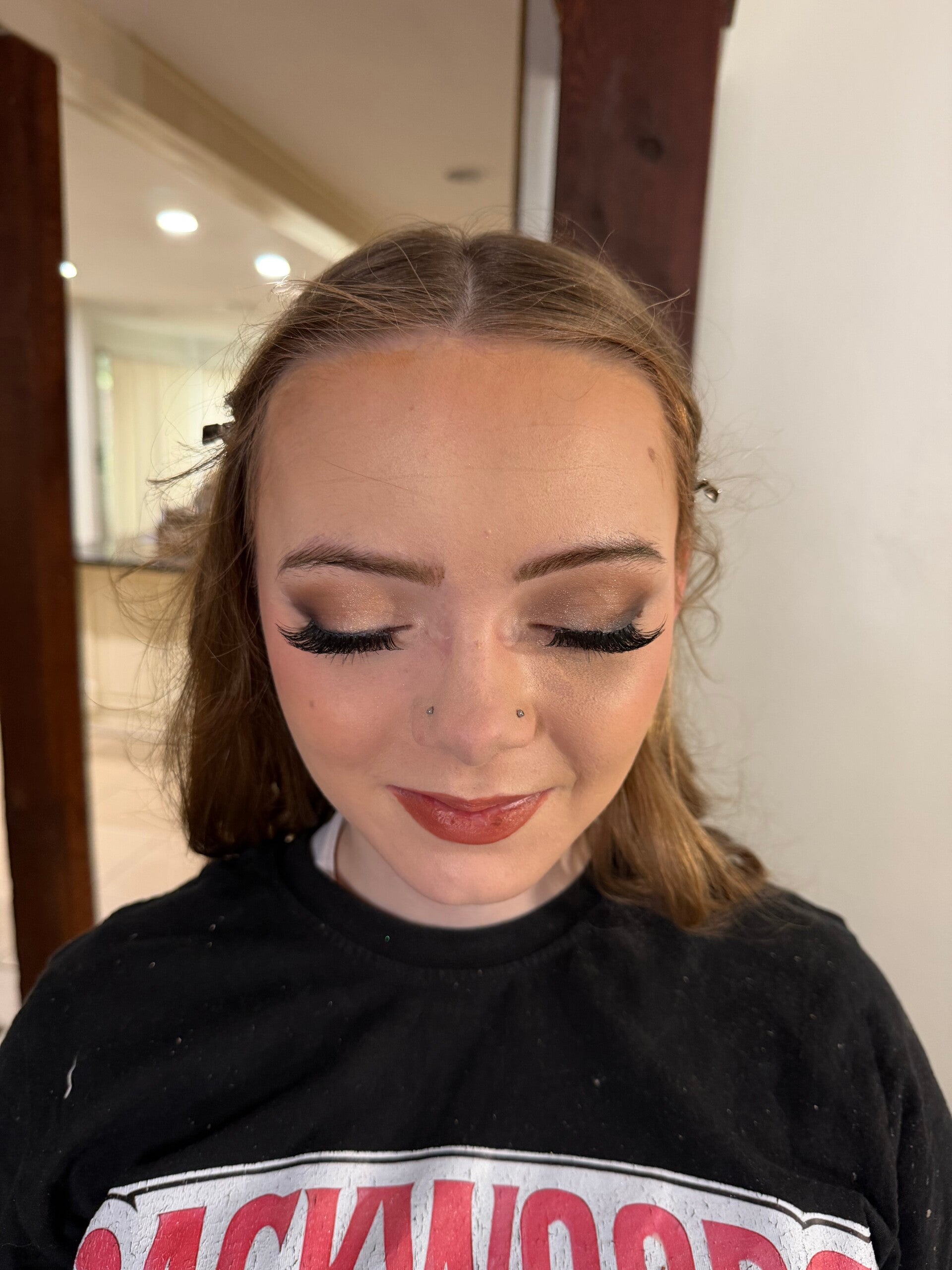 Neutral glam makeup by Ashley Quick with smoky shimmer eyeshadow, defined lashes, and a glossy rose lip.
