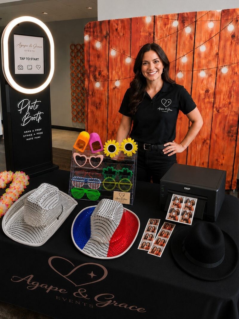 Ashley Quick beside the Agape and Grace Events photo booth, colorful props and photo printer.