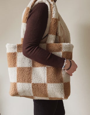 zachte tas in teddy stof met grote blokken in camel en beige, over schouder gedragen