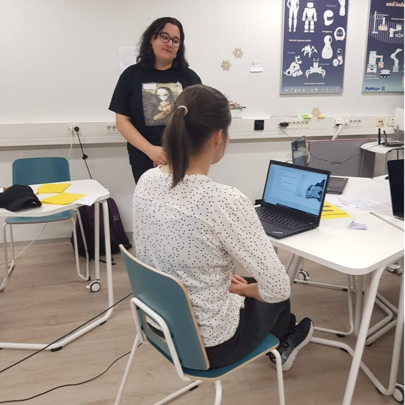 Me facilitating my Masters Thesis Pilot study. This Pilot was done in cooperation with Utelias Technologies Oy. I am observing one of my participants using AI Assessment tool on laptop.