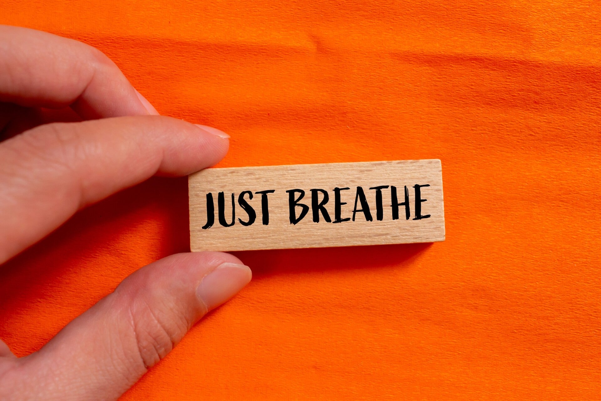 hand-holding-wooden-block-that-says-just-breathe