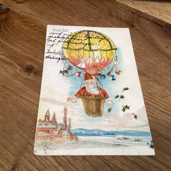 Antieke kerstkaart in reliëf uit zweden God Jul! Kerstman in luchtballon
