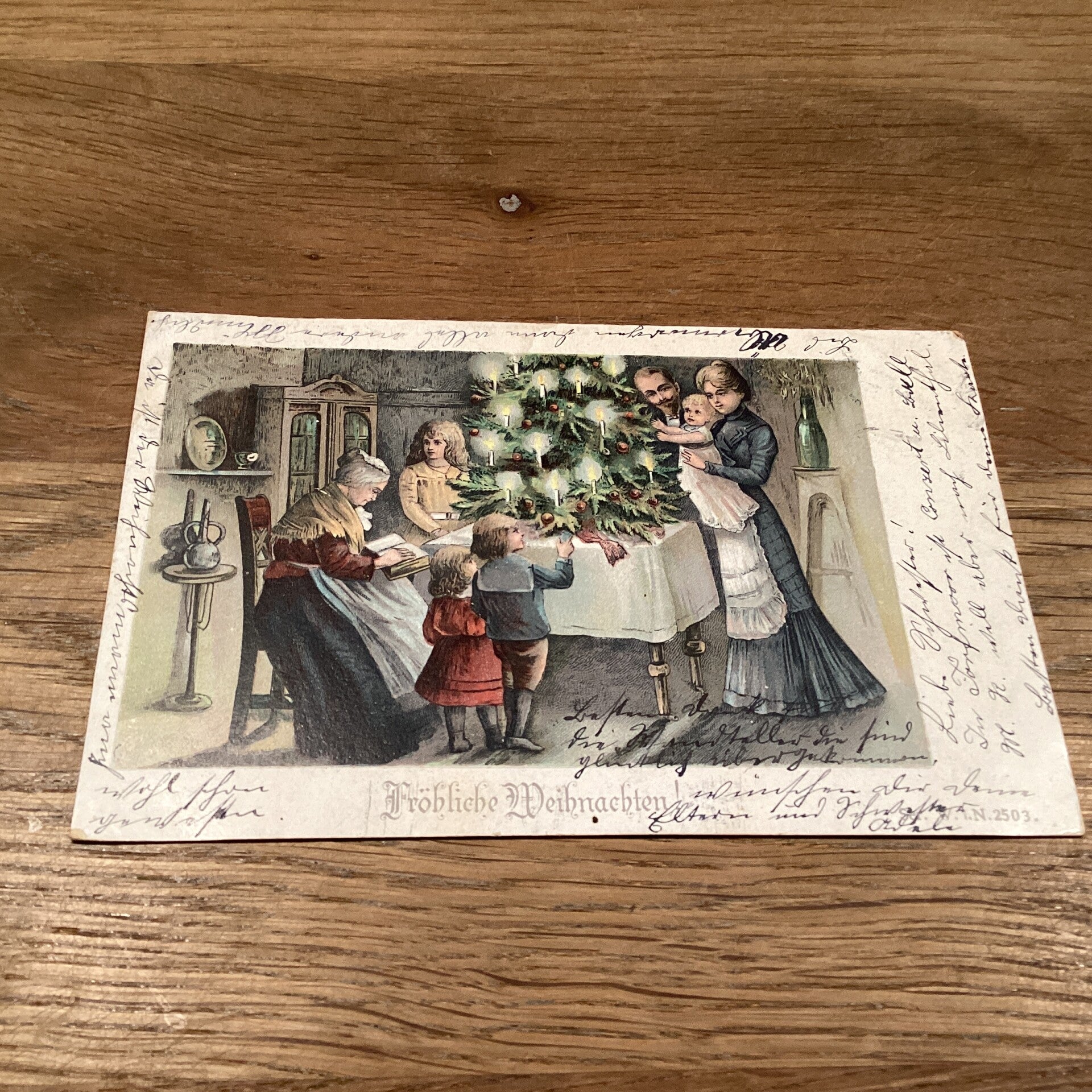 Antieke kerstkaart gezin rond kersttafel met boom, 1904
