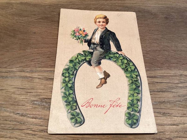 Antieke verjaardagskaart in reliëf, 1929 kind op hoefijzer klavertje vier