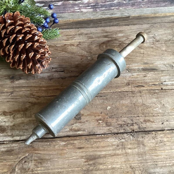 Antieke slagroomspuit van zwaar ijzer