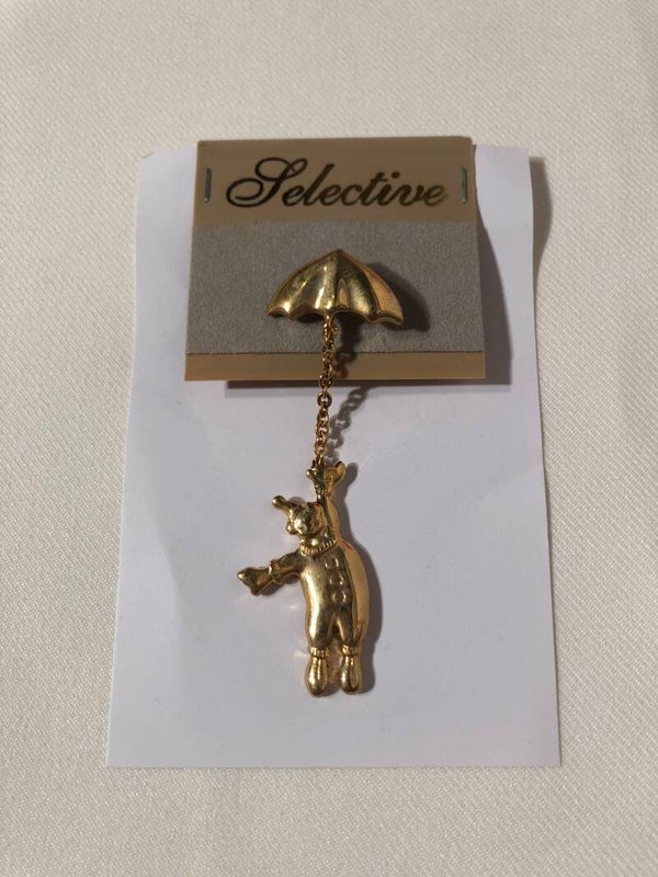 Goudkleurige broche clowntje aan paraplu