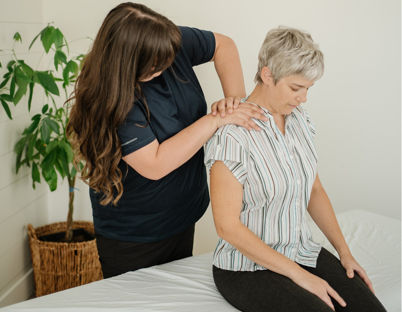 Registered massage therapist performing RAPID Neurofascial Reset on a client's shoulder to reduce pain and improve mobility
