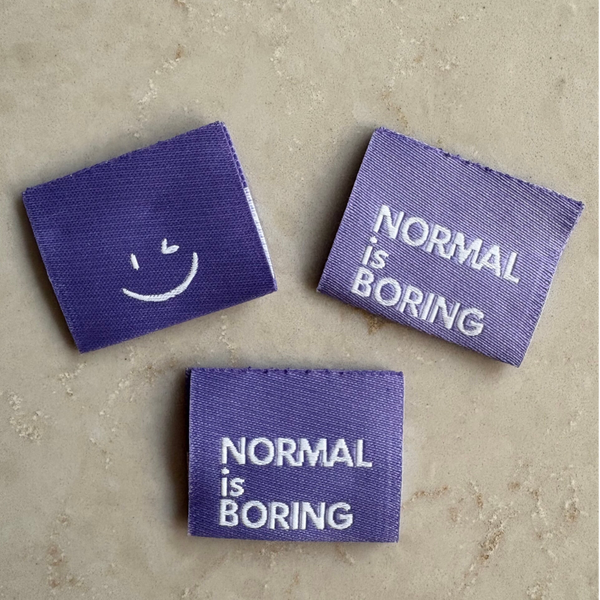 Label 'Normal is Boring' - lila
