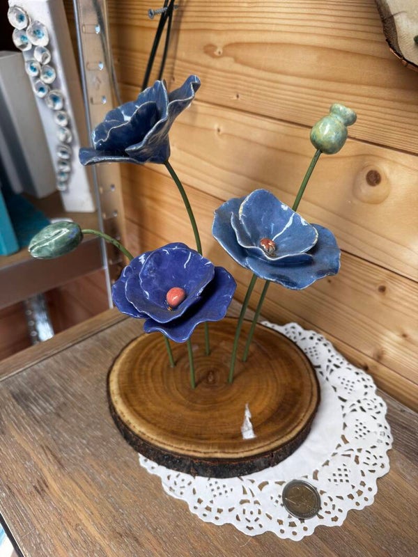 3 Blauwe klaprozen op rond hout