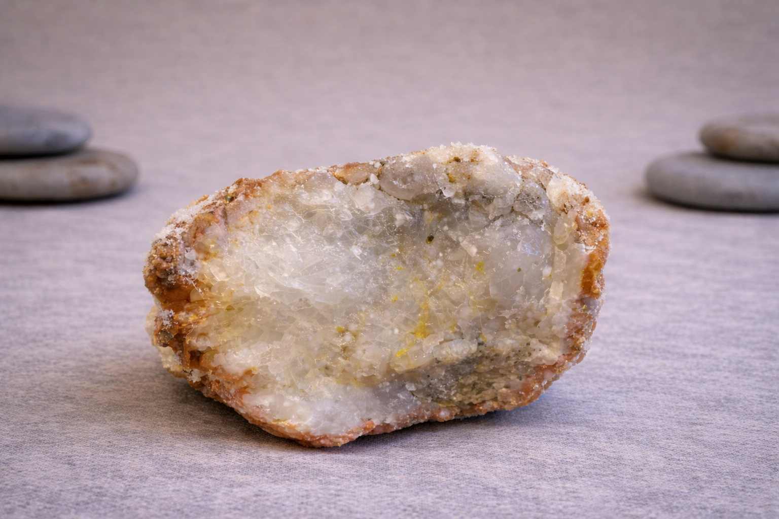 Druse d’agate rouge naturelle, présentant des cristaux clairs au cœur de la pierre, posée sur fond neutre.