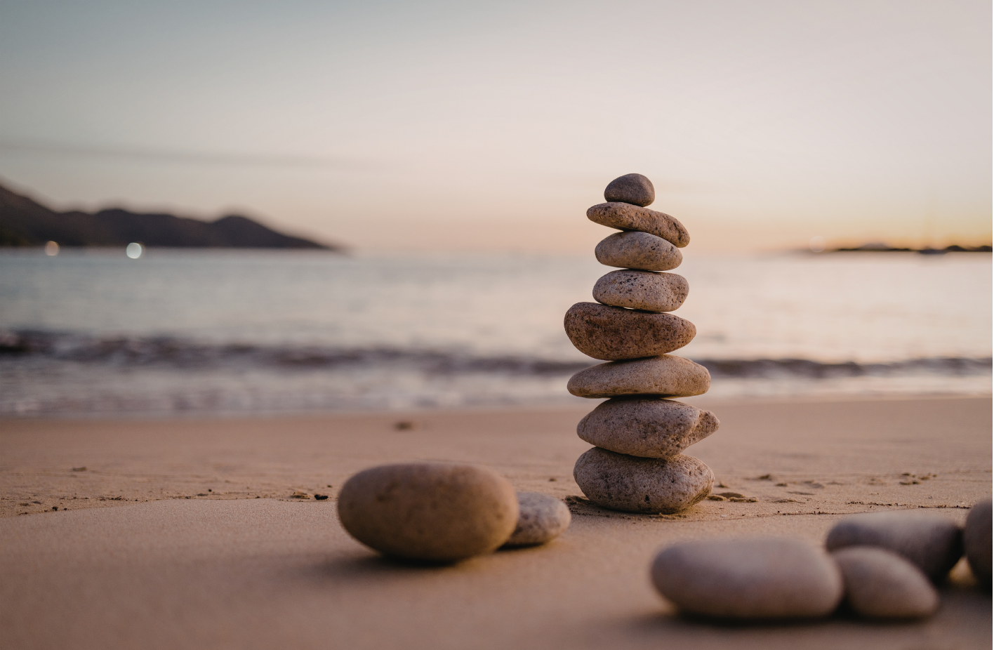 Afbeelding van balans stenen op het strand aan zee. Yin yoga brengt rust en onstpanning. Ook heel geschikt voor bedrijven om medewerkers te laten onstpannen een mobiel lichaam te behouden meer helderheid en kalmte in het hoofd te bevorderen 