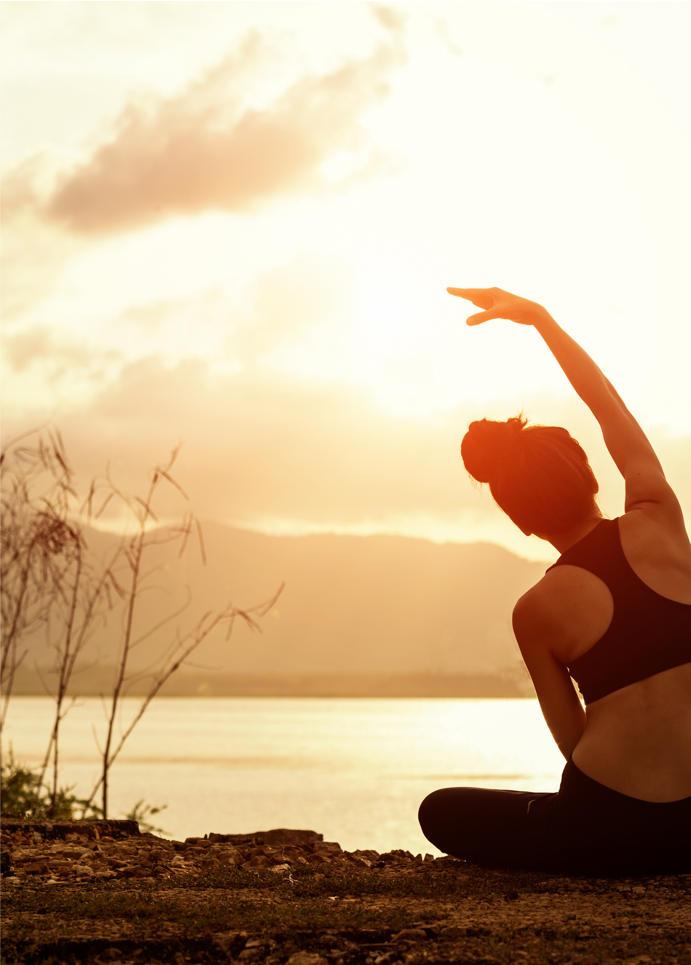 foto van een dame die yoga beoeftend buiten aan het water bij een zonsondergang. Je Zachtkacht yogales in Lieren Beekbergen Apeldoorn Hoenderloo Loenen Klarenbeek voor onstpanning verzachting herstel na burn-out overprikkeld zijn ademhaling 