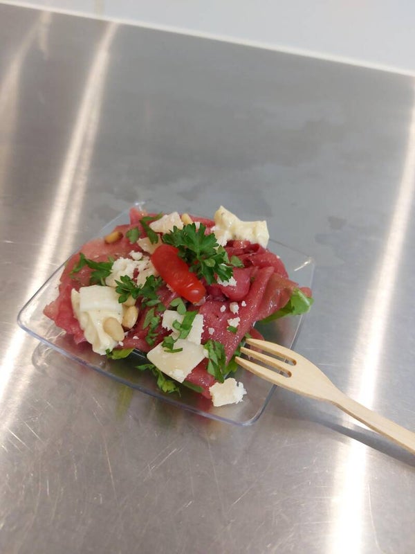 Bordje met carpaccio, rucola, truffelmayonaise, pijnboompitten en Parmezaanse kaas.