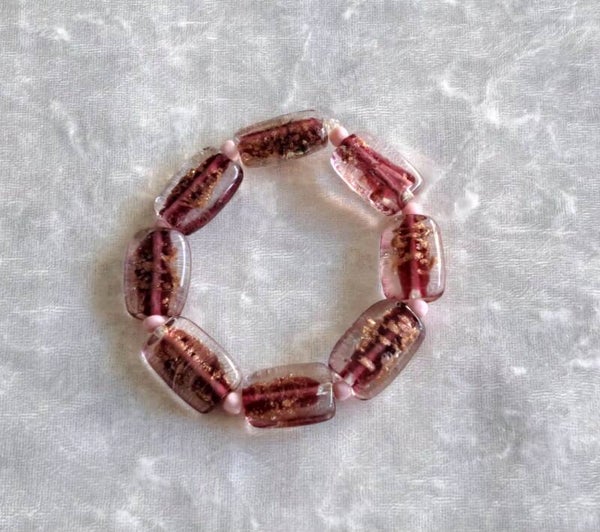 Armband donker roze met goudvlokjes. Elastisch.