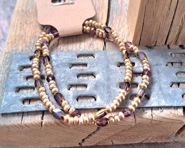 Armbanden goud met paarse tussenkralen. Elastisch.