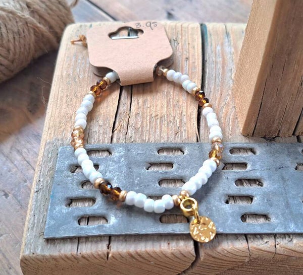 Armband bruin/wit met munt. Elastisch.
