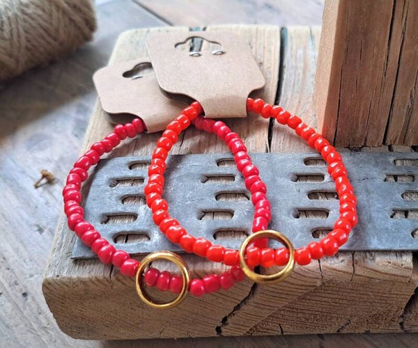 Armbanden rood met goudkleurige ring. Elastisch.