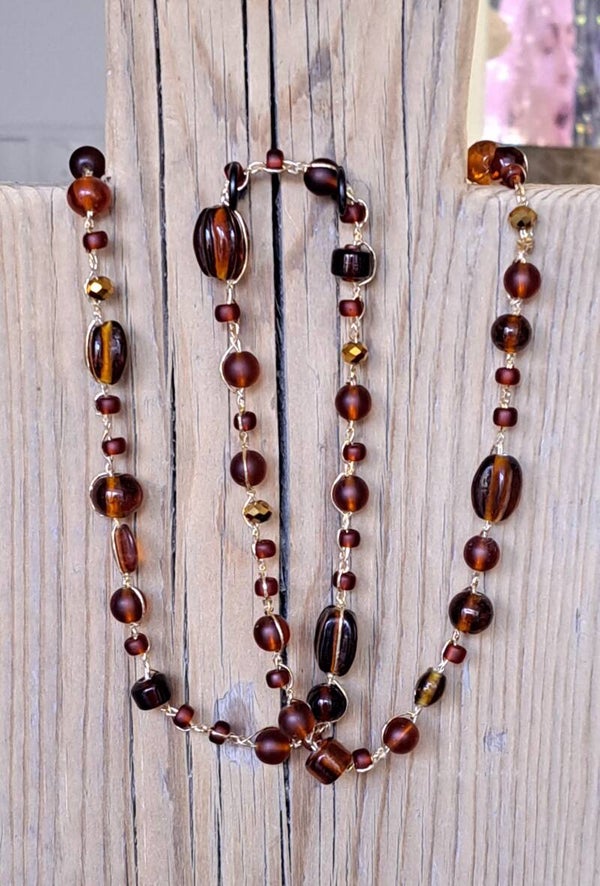 Ketting gehaakt bruin. Diverse verschillende kralen. 70 cm.