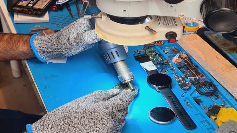 Techniker bei der Reparatur eines Garmin Forerunner in der Werkstatt in Leverkusen