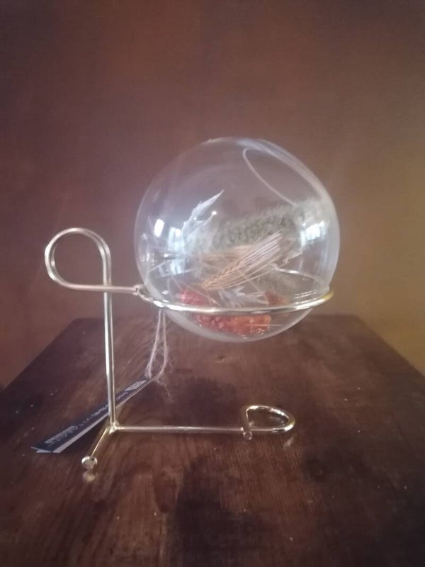 Gouden standaard met glazen bol, gevuld met droogbloemen