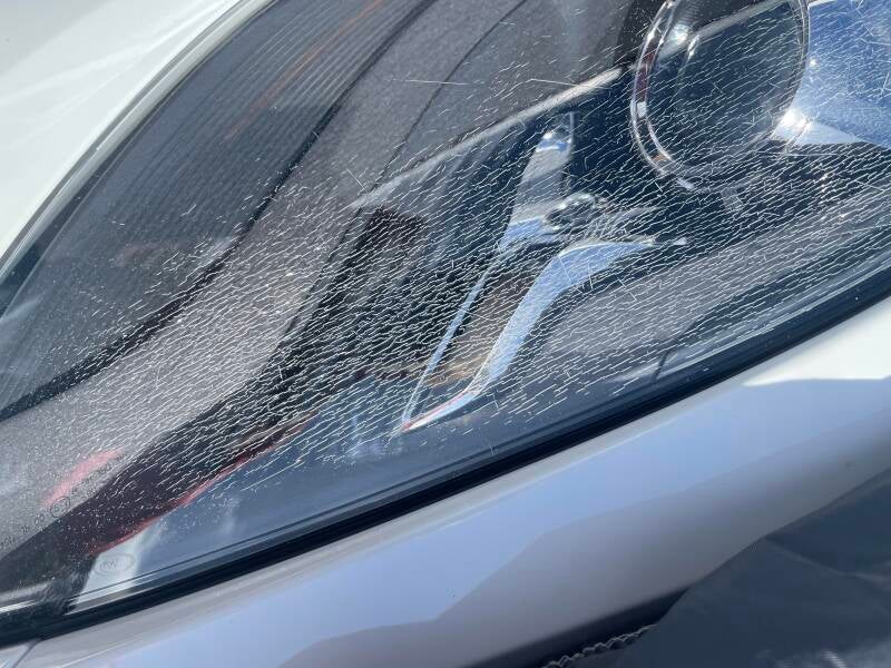 porsche met haarscheurtjes als een spinnenweb in de koplamp