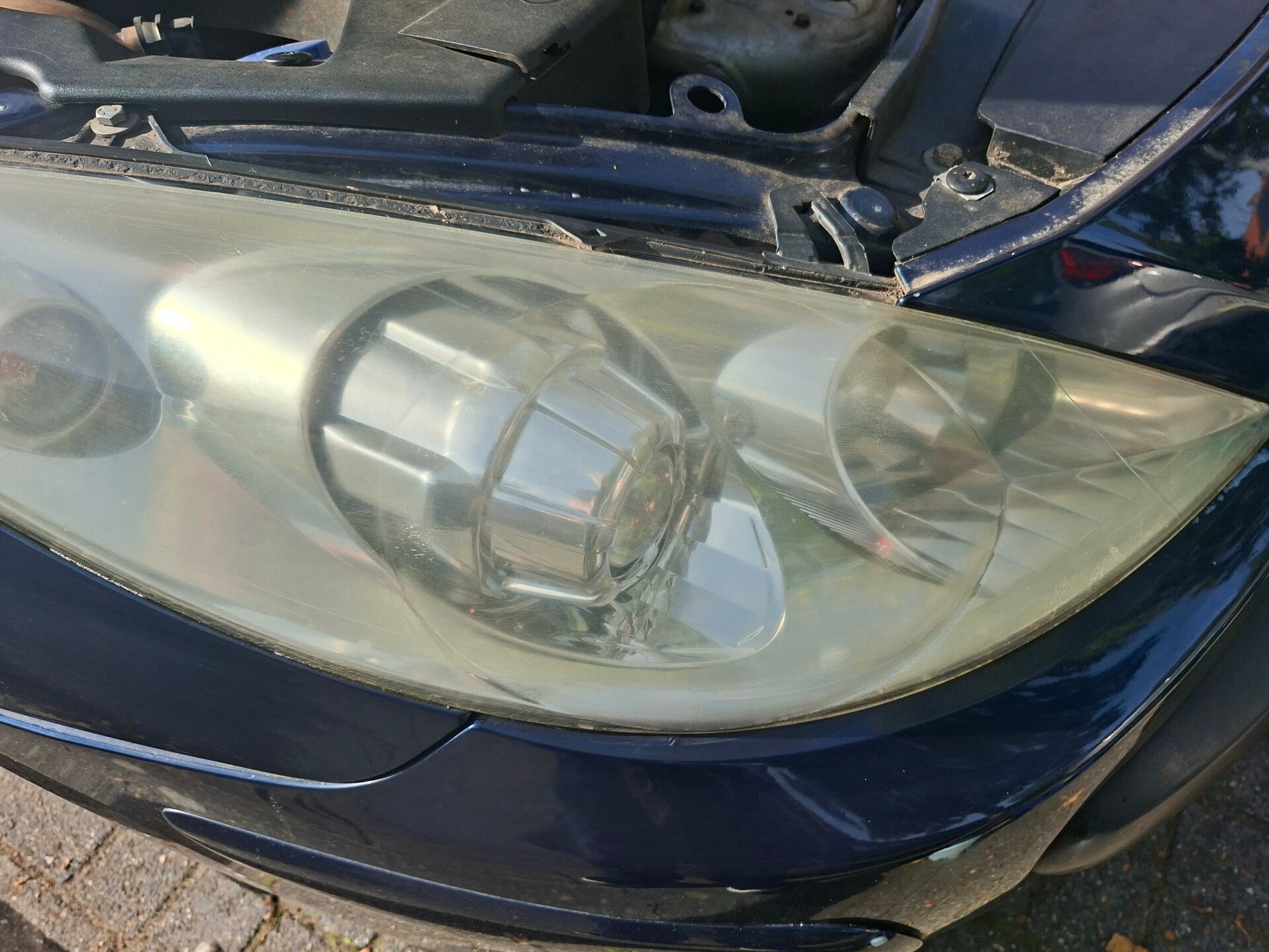 Doffe gele koplamp van een Peugeot voor polijsten