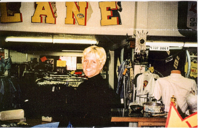 Photo of Maya Frost, founder of Collapse Forward, sitting behind the counter at Retro Active, the vintage/resale clothing store she owned in Forest Grove, Oregon in the 1990s.