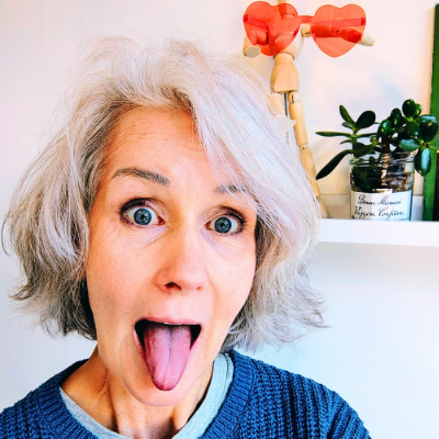 Maya Frost sticking out her tongue to impersonate a famous photo of Albert Einstein doing the same.