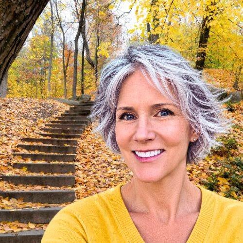 Maya Frost, founder of Collapse Forward, creator of Lucid Longing,  in forest with yellow leaves