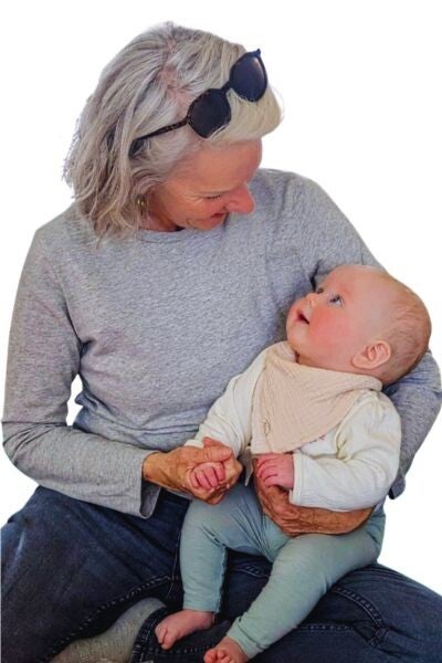 Photo of Maya Frost, creator of Collapse Companioning and a creative adaptation and personal resilience expert, holding a  baby .