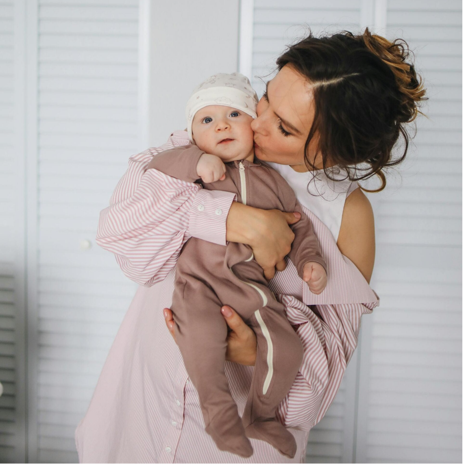 Nainen halaa ja antaa pusun vauvalle