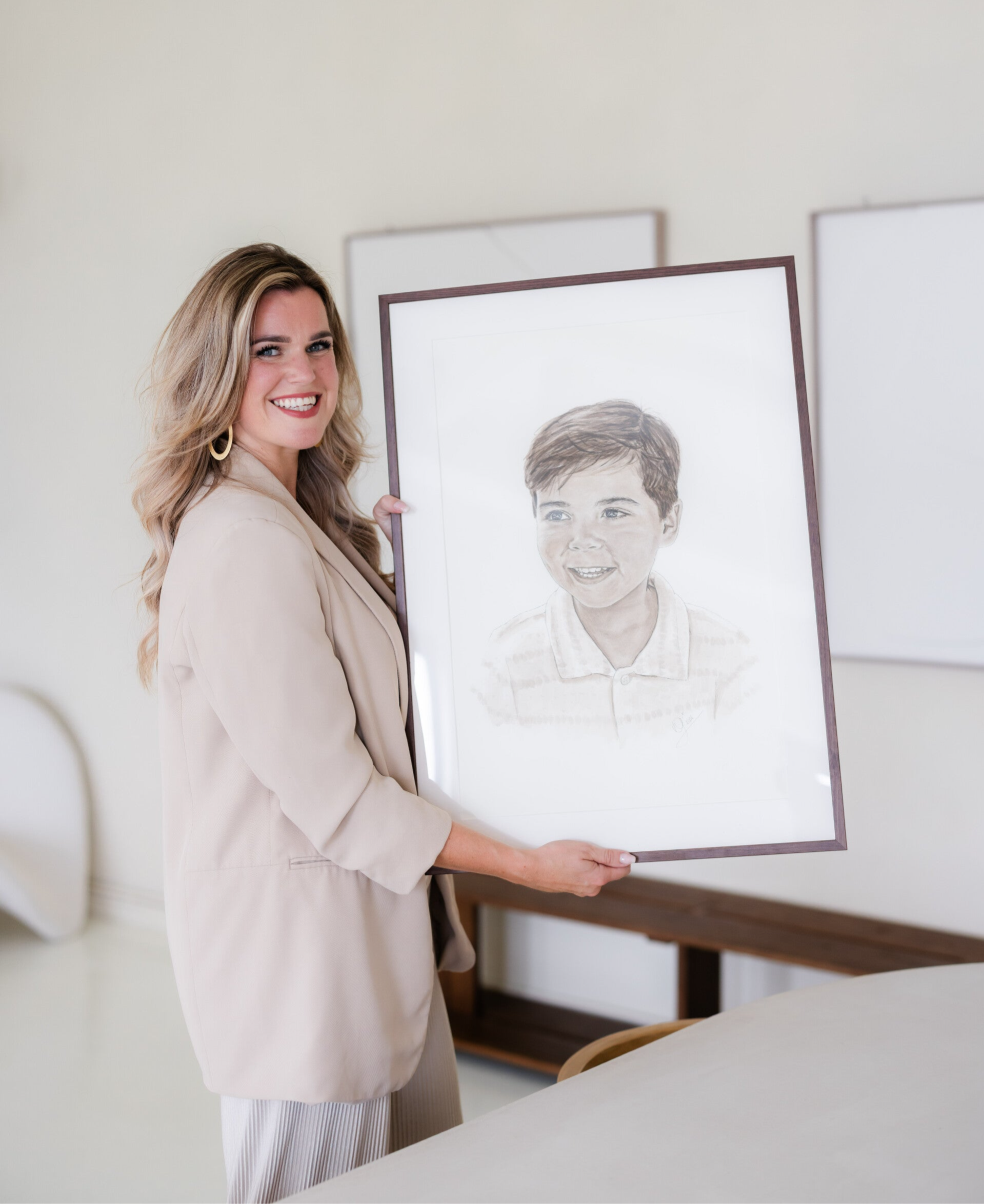 kunstenares houdt ingelijst portret vast