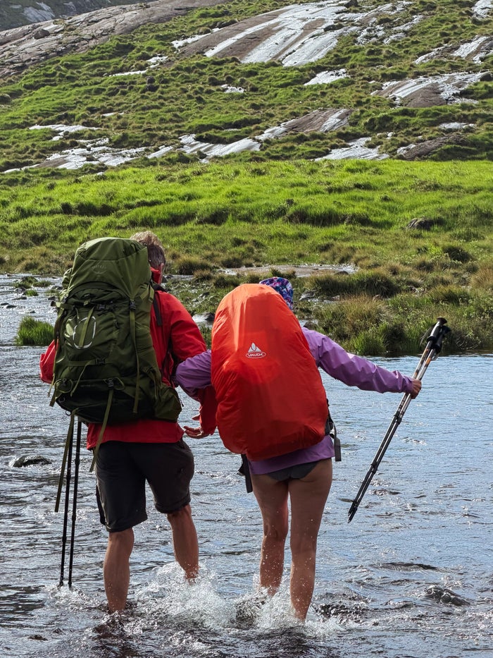 Een rivier oversteken tijdens de huttentocht in Schotland
