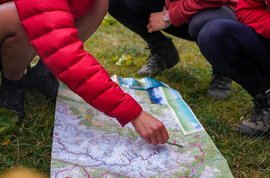 Deelnemer oefent kaartlezen en kompasgebruik tijdens de Survival & Navigatie-cursus