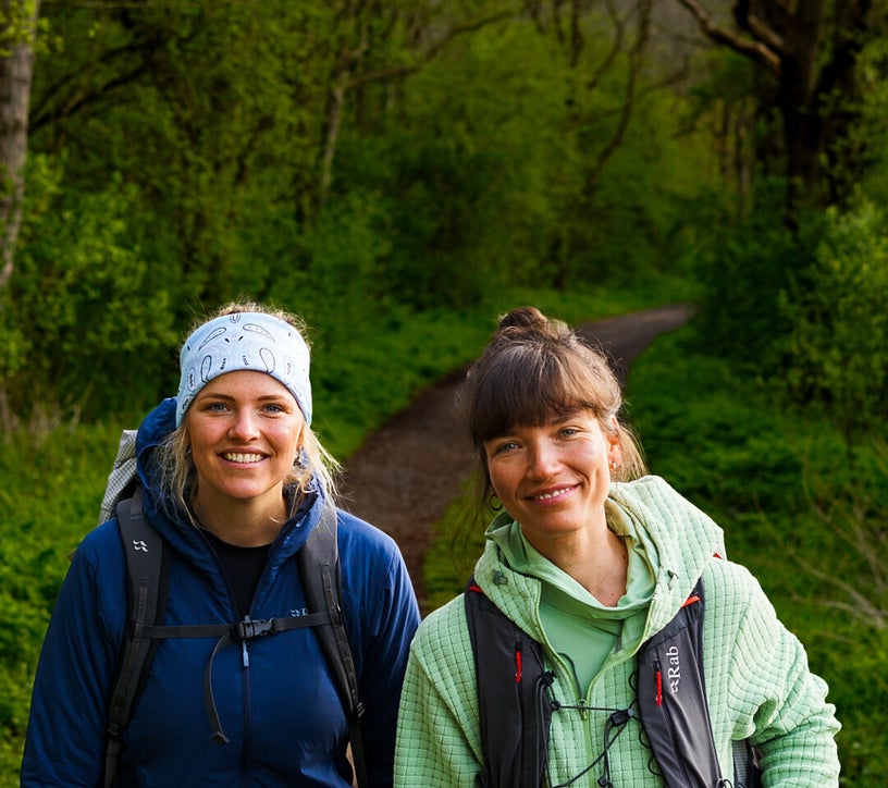 Twee reizigers van Via Nomade wandelen samen door het bos