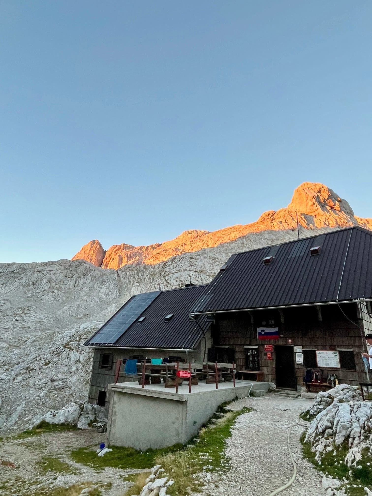 Berghut met zicht op een bergtop in het avondlicht, Julische Alpen