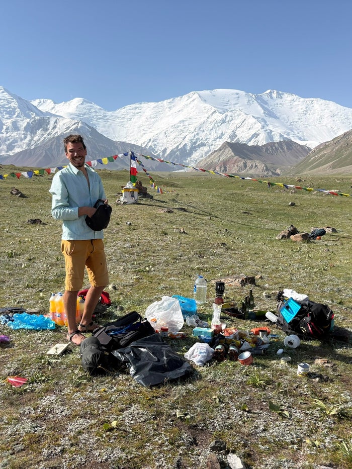 Uitrusting uitgepakt in de wei met uitzicht op Lenin Peak