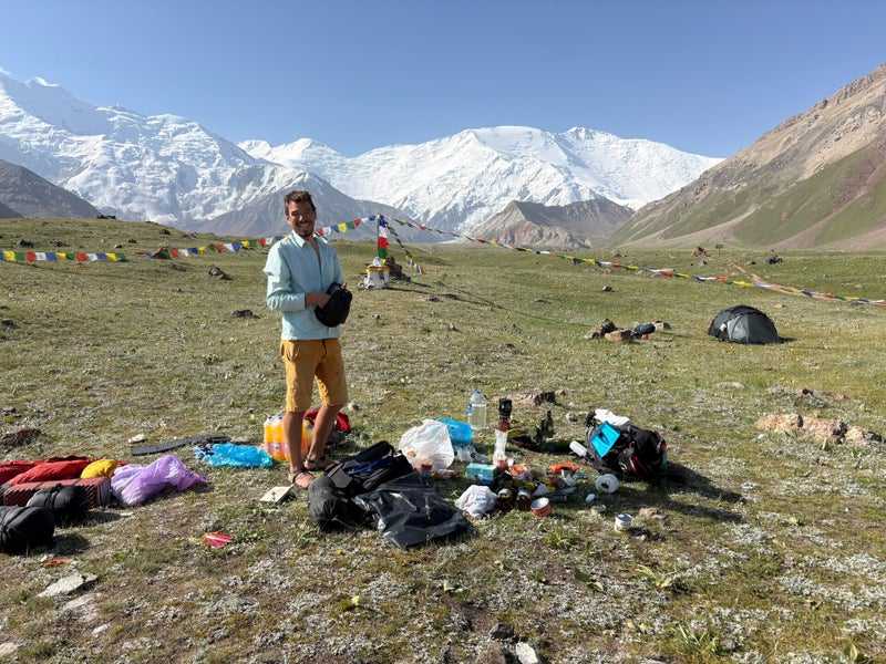 Uitrusting uitgepakt in de wei met uitzicht op Lenin Peak