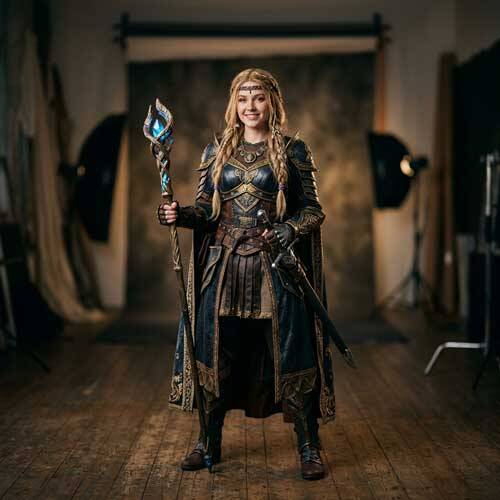 Frau in einem aufwendigen Fantasy-Kostüm mit Rüstung und magischem Leuchtstab