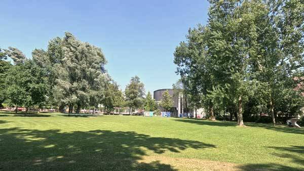 Das runde Gebäude des Planetariums hinter einer Grünfläche.