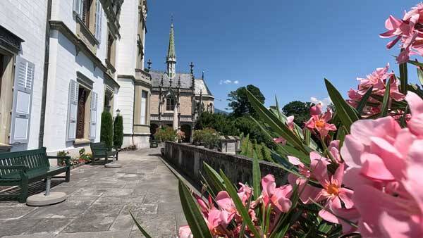 errasse des Herrenhauses mit rosa Blumen und Bänken.