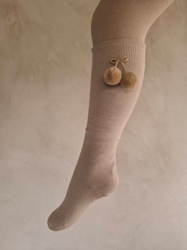 Kniekous met pompomstrik in hele mooie beige kleur