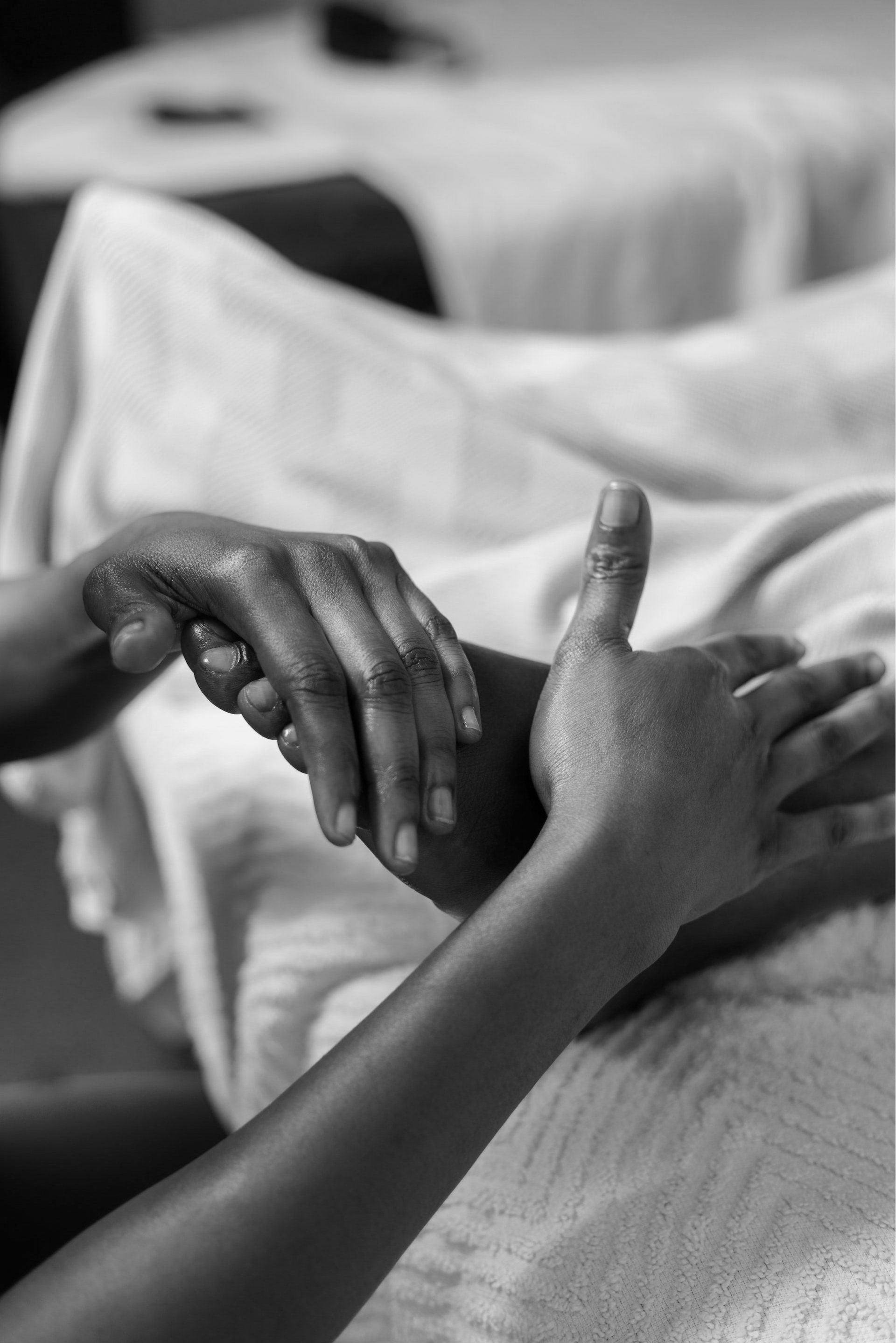 Formation en réflexologie plantaire thaïlandaise Nuad Thao, gros plan sur la pratique d’un massage des pieds avec pression du pouce et stimulation des zones réflexes.