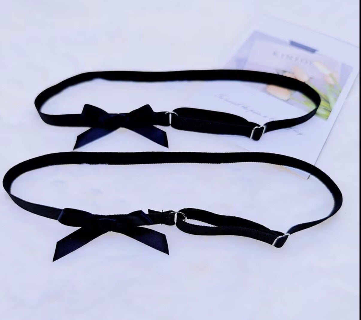 One pair of black garters with bow