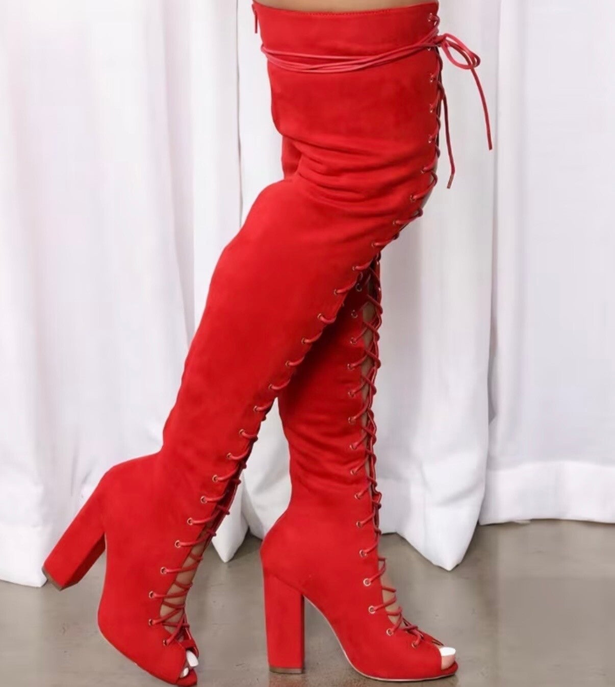 Luxurious thigh-high lace-up boots in bold fiery red suede.