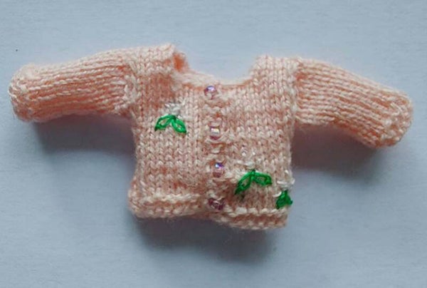 Roze babyvestje met witte bloemetjes-Pink baby cardigan with white flowers