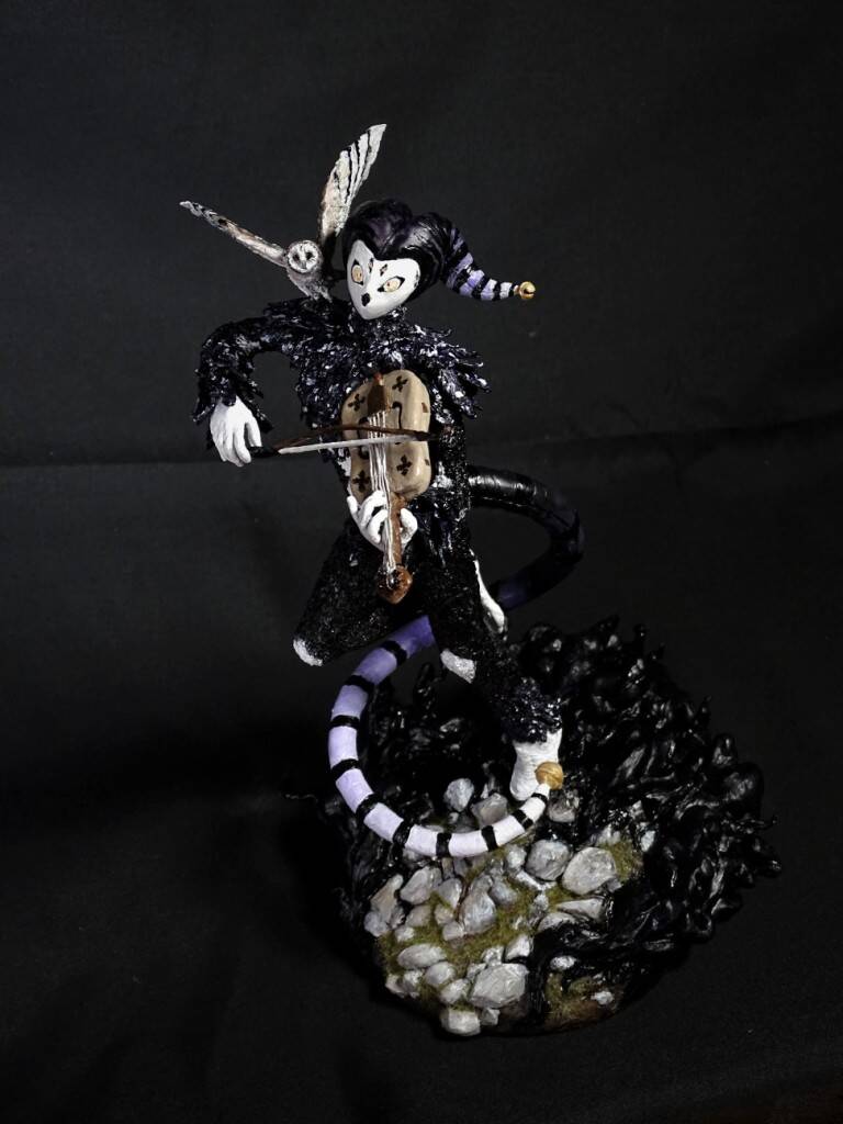 Seltsamer Musiker mit Federn und Maske. Skulptur von Josi Saefkow.