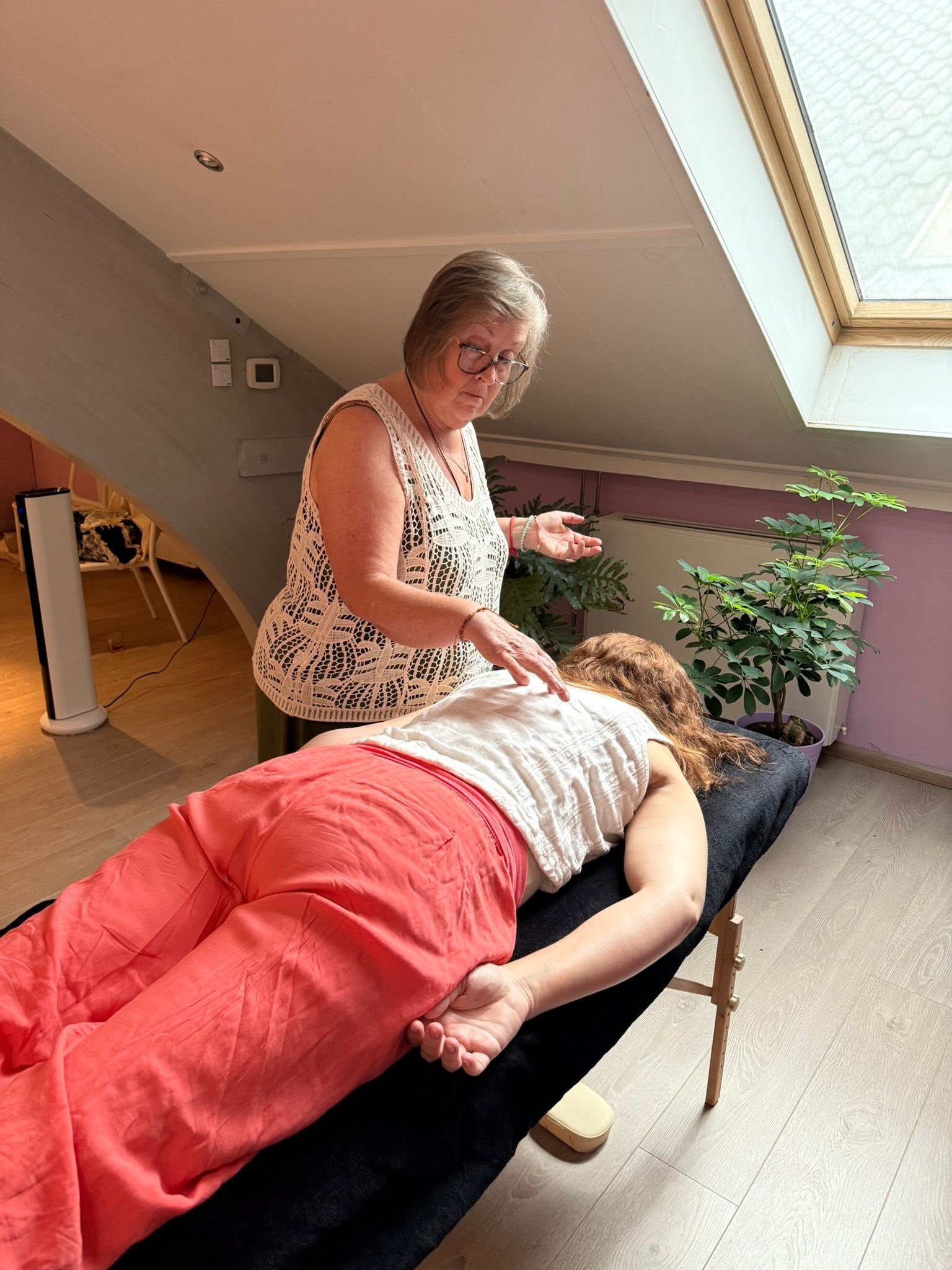 Bets de Jong geeft een Talking to the Chakra's behandeling bij een client die op haar behandeltafel ligt. Dit is de chakra dialoog. Via de chakra's komen de trauma's naar boven die blokkades hebben veroorzaakt. Door de TCC wordt de connectie hersteld.