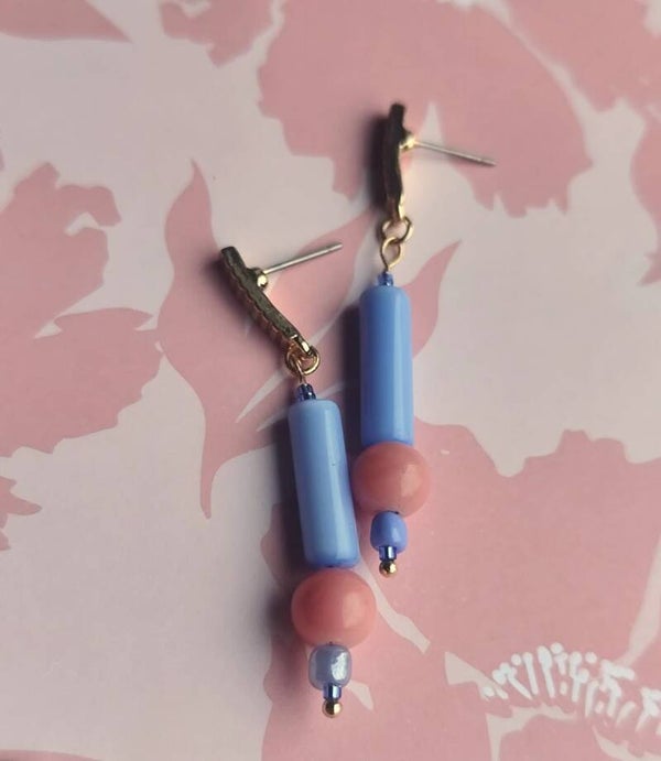 Stijlvolle goudkleurige steker met mooie blauw-roze glazen parels